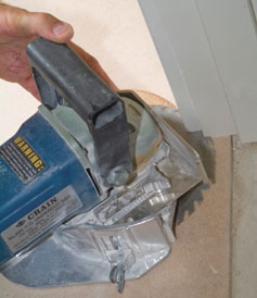 一个切边锯修剪外壳和门框非常接近地板，这样乙烯基板可以塞在下面。