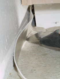 弯曲的乙烯基刀的背面可以帮助你找到地板与墙壁的交汇点。