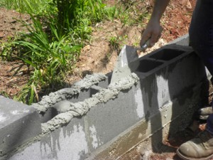 将干燥的混凝土彻底浸湿，然后用镘刀涂抹砂浆和砌块。清除接缝处多余的灰浆。