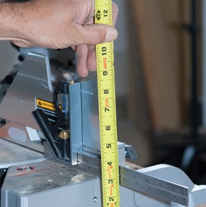 将翼板放在锯底座旁边的桌子上，从翼板测量到锯面，以确定翼板支撑块的高度。