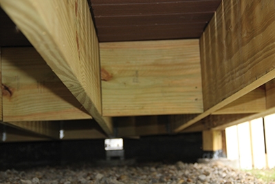 小段的搁栅材料可以安装在搁栅之间作为跨中阻塞，以帮助防止甲板反弹和加强贯穿甲板的栏杆柱附件。